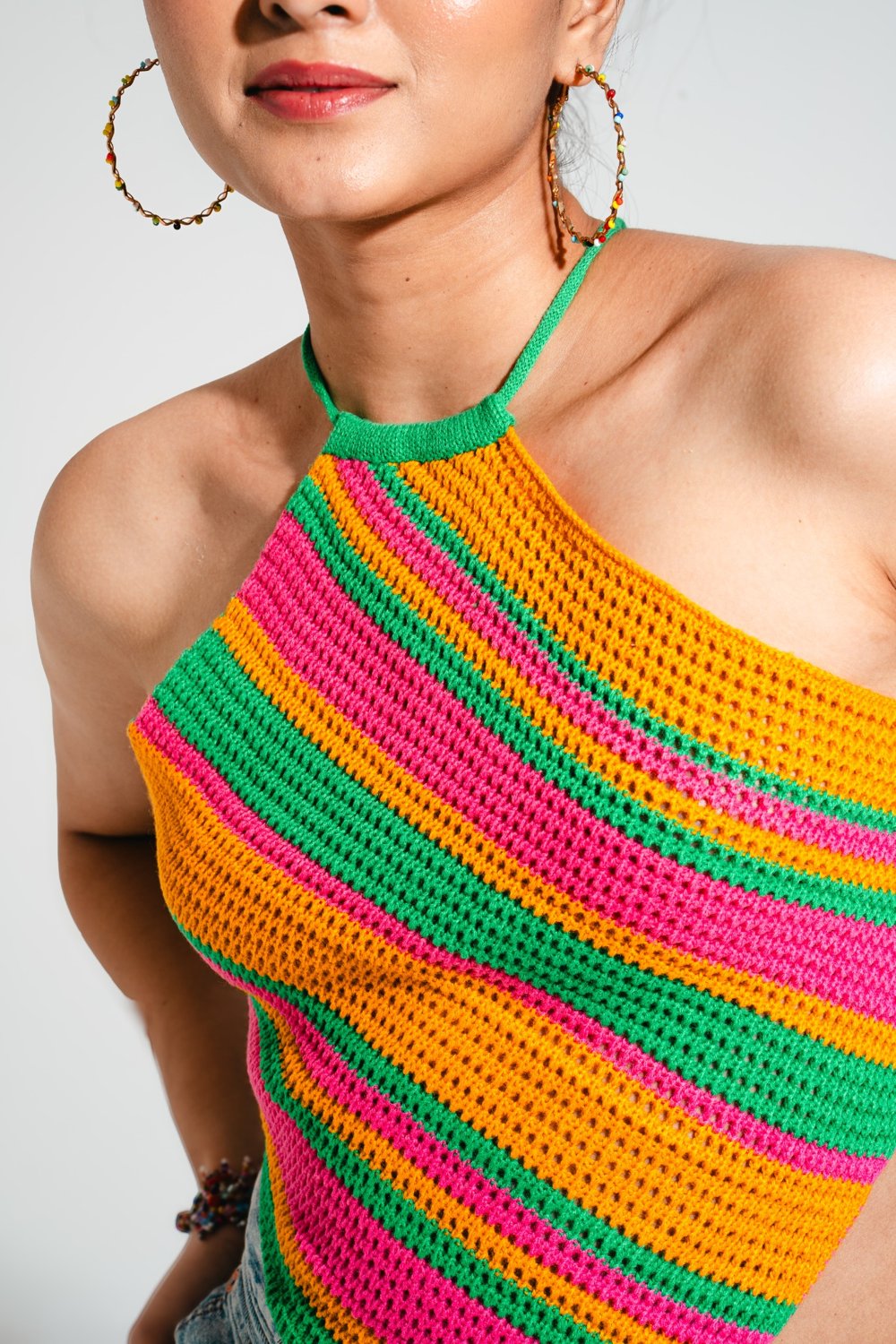 Model wearing Candy Crochet Top styled with denim mini skirt, colourful striped halter neck top