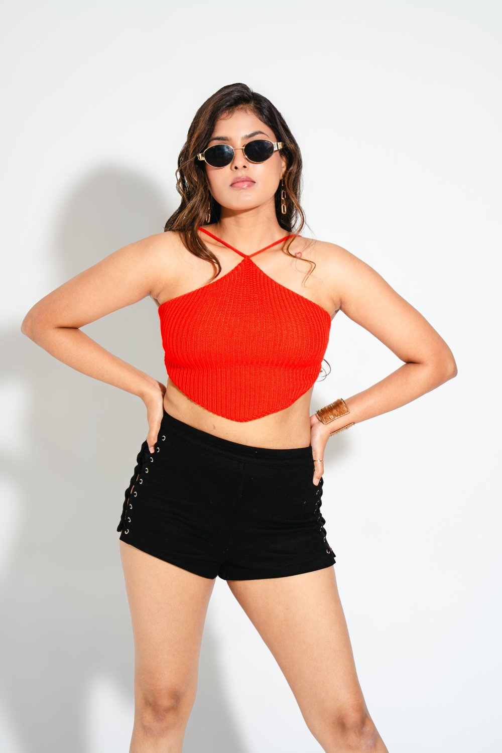Close-up of Gia Sangria Red crochet top with halter straps, styled with sunglasses for a sassy party vibe