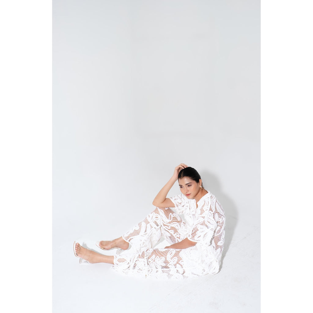 Model seated while wearing the Laurel Crochet Crochet Coord Set, highlighting the breathable knit texture and elegant resort-wear silhouette.