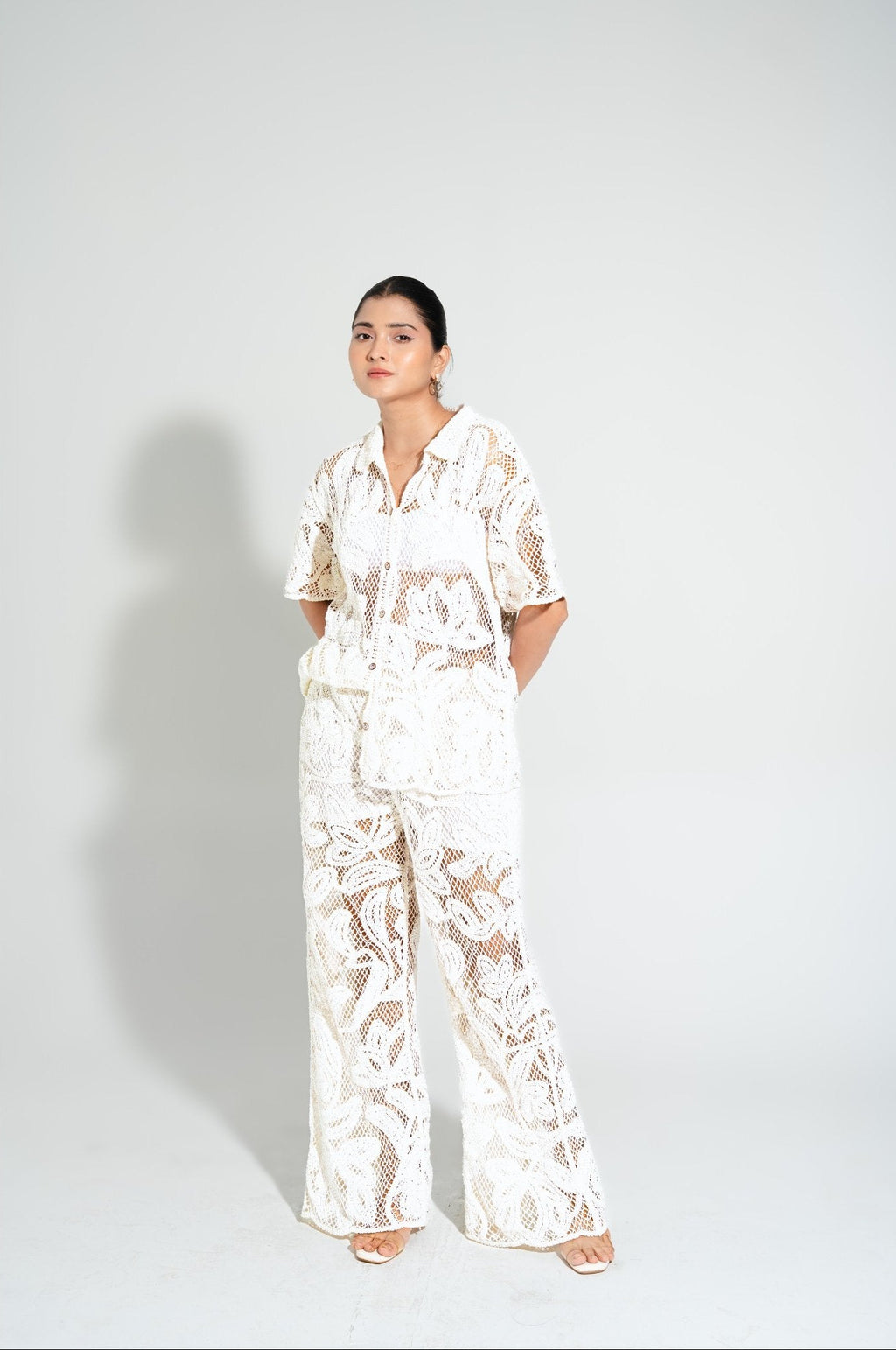 Woman wearing the Laurel Crochet Full Length Coord Set in white, showcasing the handcrafted floral crochet design and relaxed vacation-ready fit.
