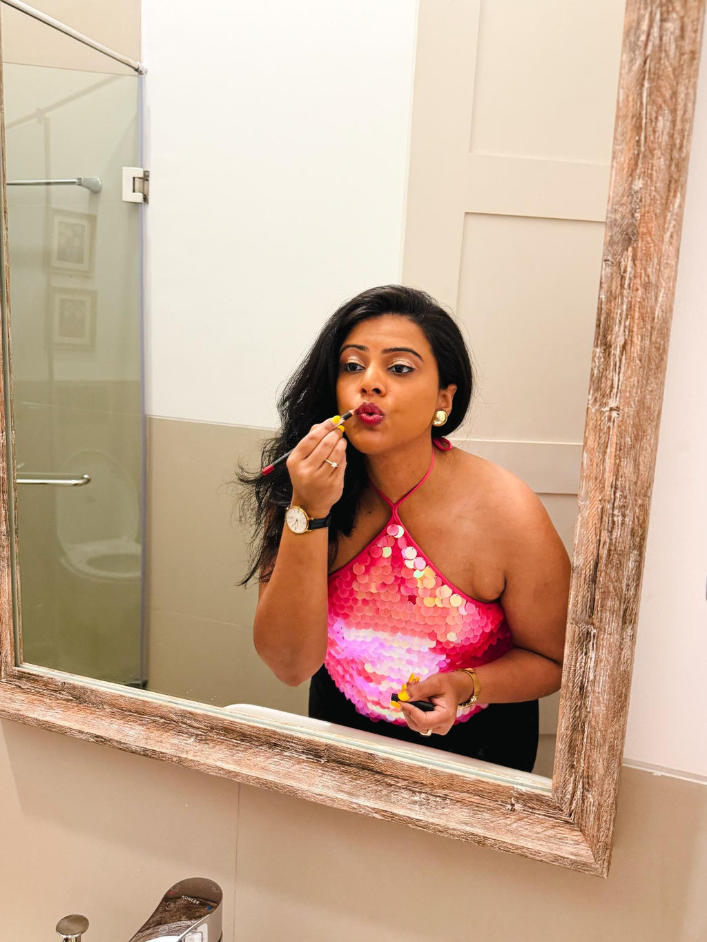 Bride-to-be styled in a pink Zoe Sequin Halter Top with shimmering sequin details, getting ready for a bachelorette or party night, captured in a mirror setting.