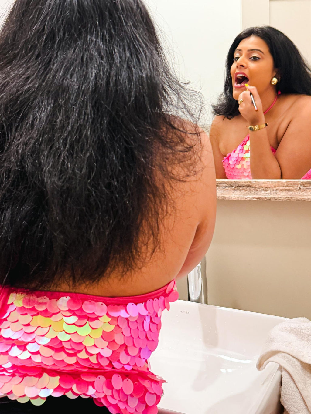 Woman wearing the Zoe Sequin Halter Top in pink, styled with soft glam makeup and statement earrings, perfect for partywear, bachelorette outfits, and Sunday night looks.